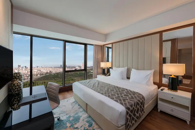 Chambre d'hôtel moderne avec un grand lit et une vue sur la ville.