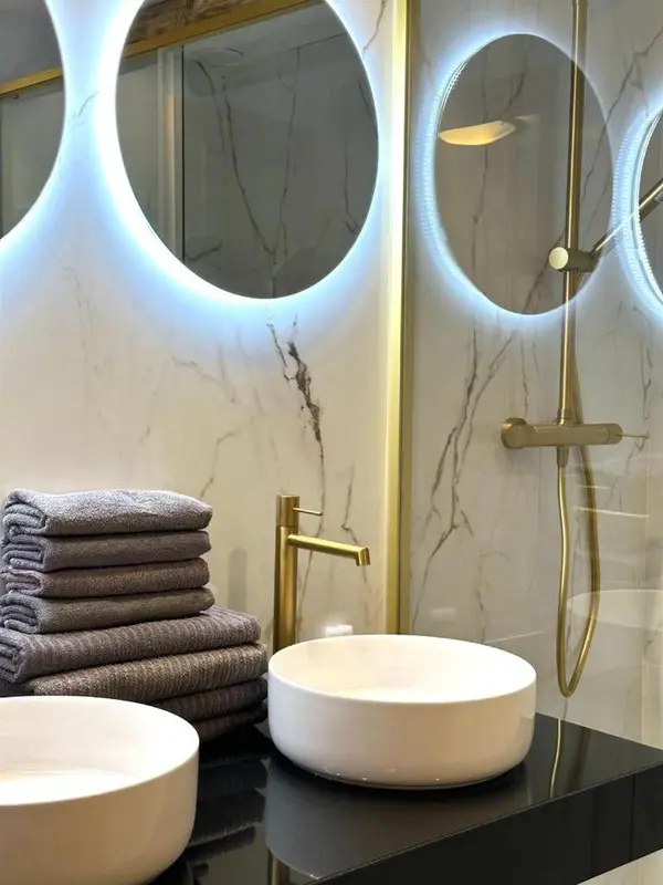 Vasques et robinetterie dorée dans une salle de bain moderne.