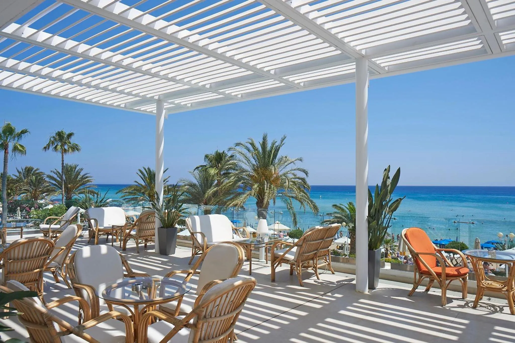 Terrasse ombragée avec mobilier de jardin face à la mer.