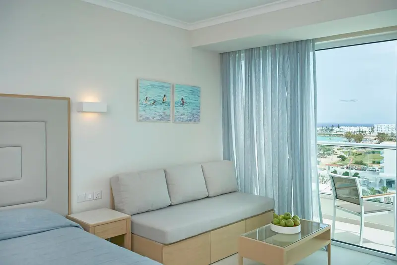 Une chambre lumineuse avec un canapé et une vue sur la mer.