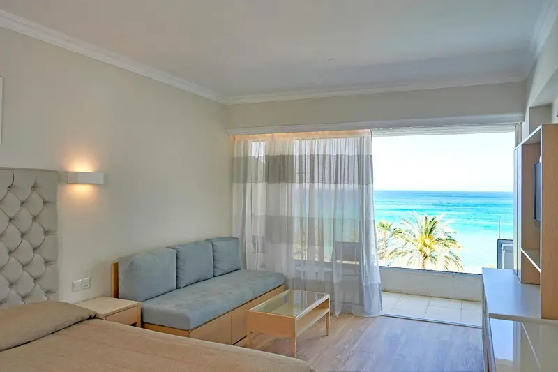 Espace de vie lumineux avec canapé et vue sur la mer.
