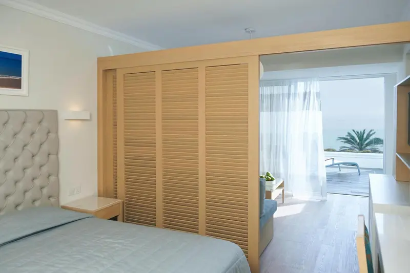 Une chambre lumineuse avec un lit et un accès à une terrasse.