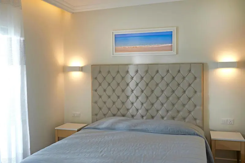 Une chambre lumineuse avec un grand lit et une décoration sobre.
