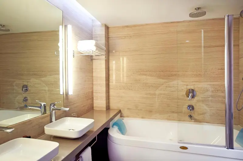 Une salle de bain moderne avec deux vasques et une baignoire.