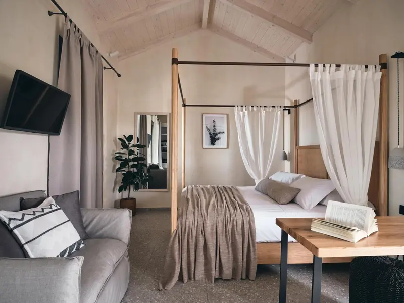 Une chambre lumineuse avec un lit à baldaquin et un canapé.