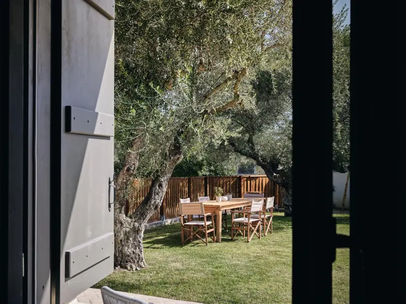 Une table à manger en bois est installée sur une pelouse verdoyante.