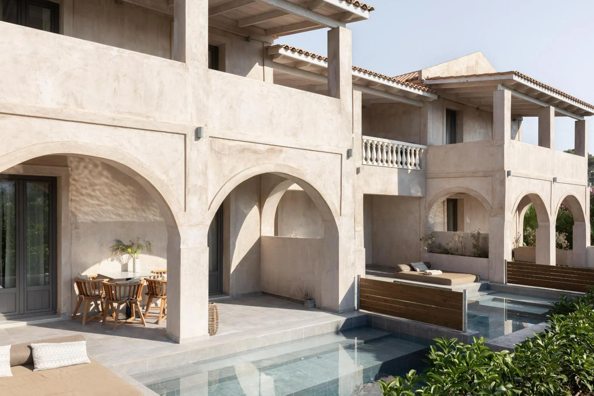 Terrasse ombragée avec mobilier de jardin et piscine.
