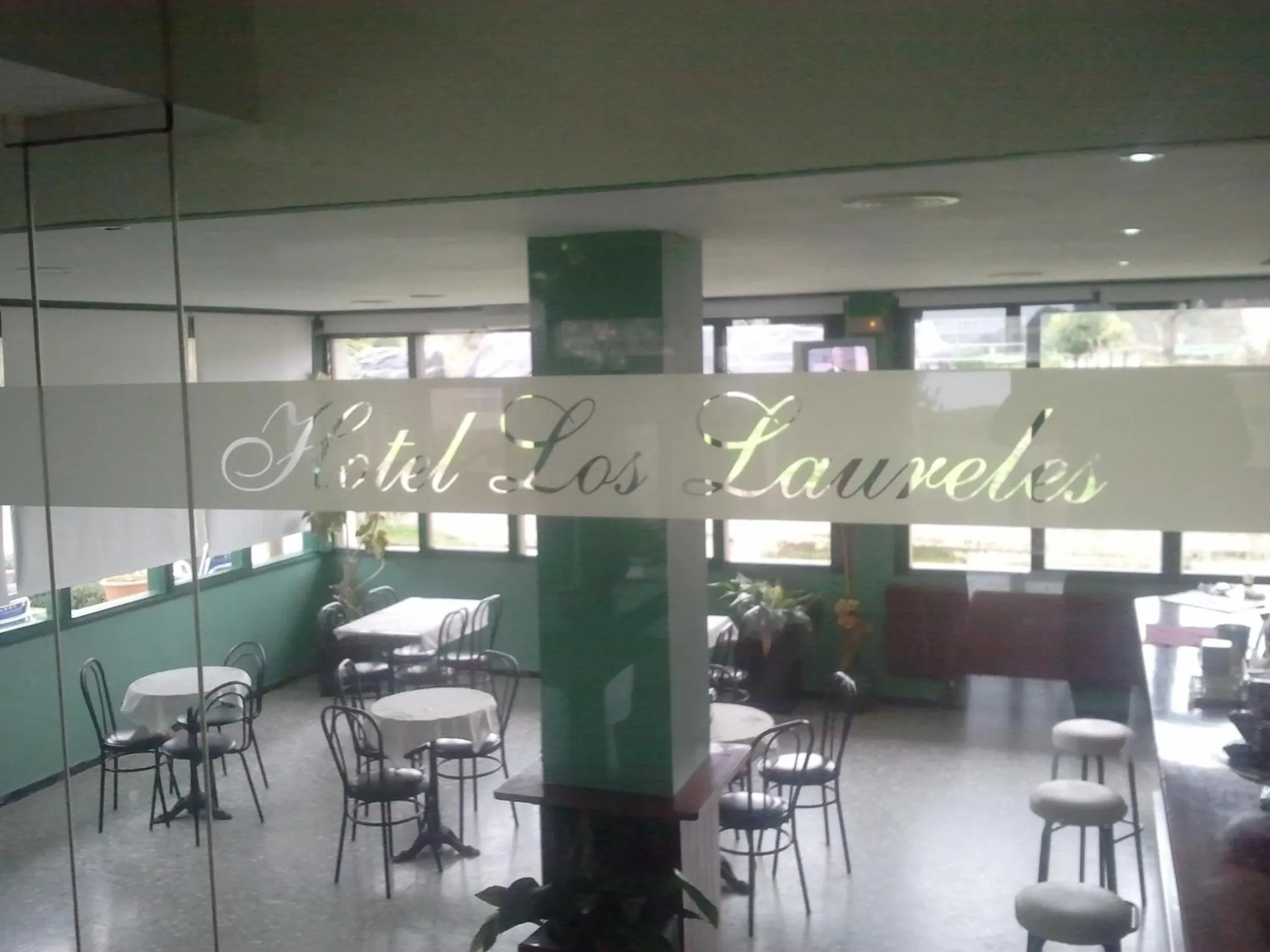 Une salle à manger lumineuse avec des tables rondes et des chaises.