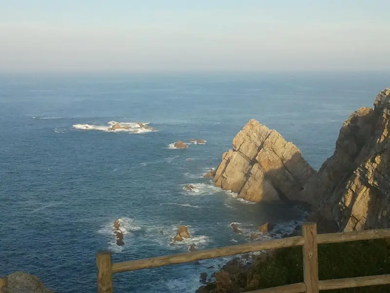 Vue panoramique sur la mer et les formations rocheuses côtières.