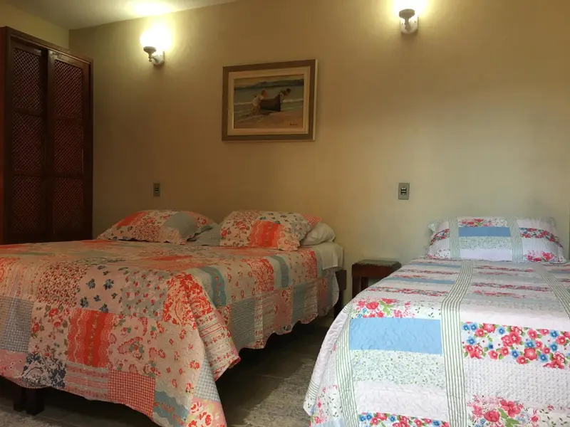 Une chambre avec deux lits recouverts de courtepointes colorées.