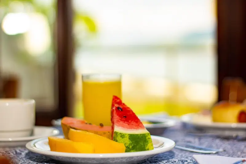 Une table est dressée avec des fruits frais et une boisson.