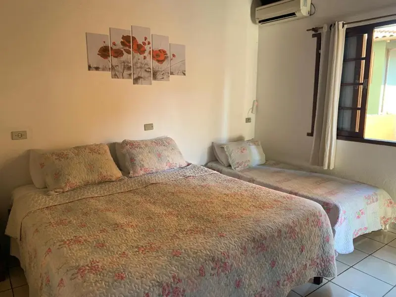 Une chambre avec deux lits recouverts d'une courtepointe fleurie.