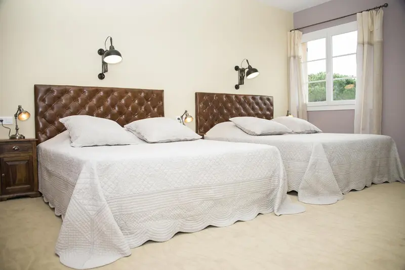 Une chambre avec deux lits simples et des chevets.