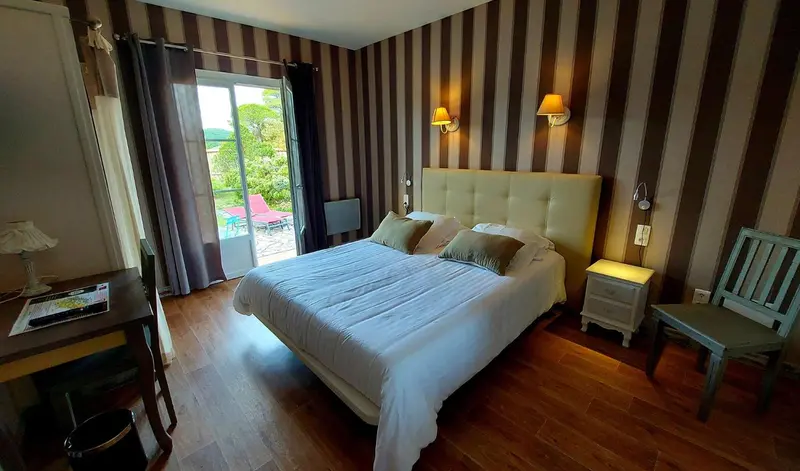 Une chambre lumineuse avec un grand lit et un accès à une terrasse.