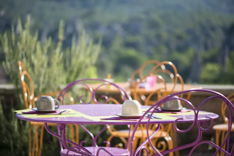 Tables colorées dressées pour un repas en extérieur.