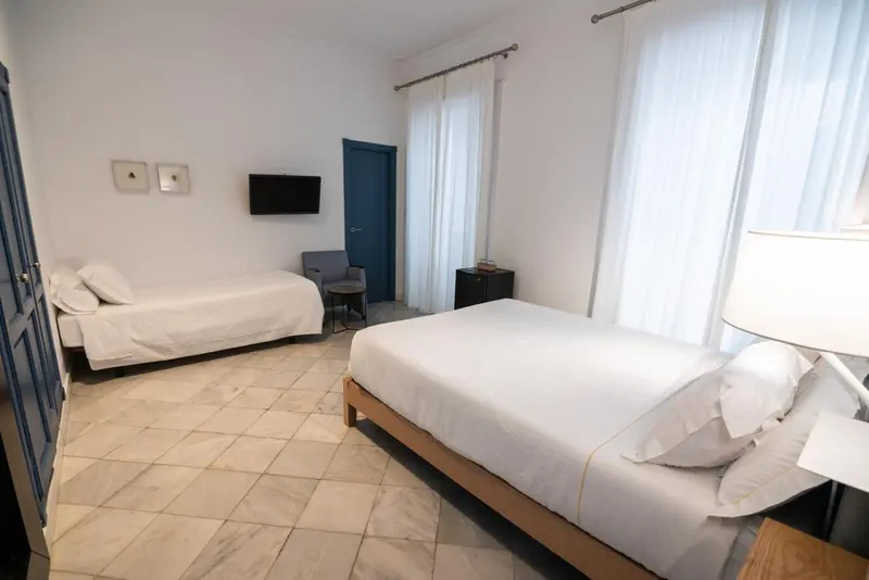 Une chambre lumineuse avec deux lits simples et une table de chevet.