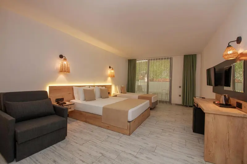 Une chambre lumineuse avec un grand lit et un coin salon.