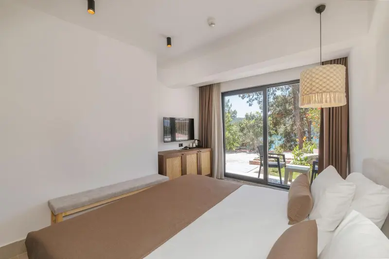 Une chambre lumineuse avec un grand lit et un accès à une terrasse.