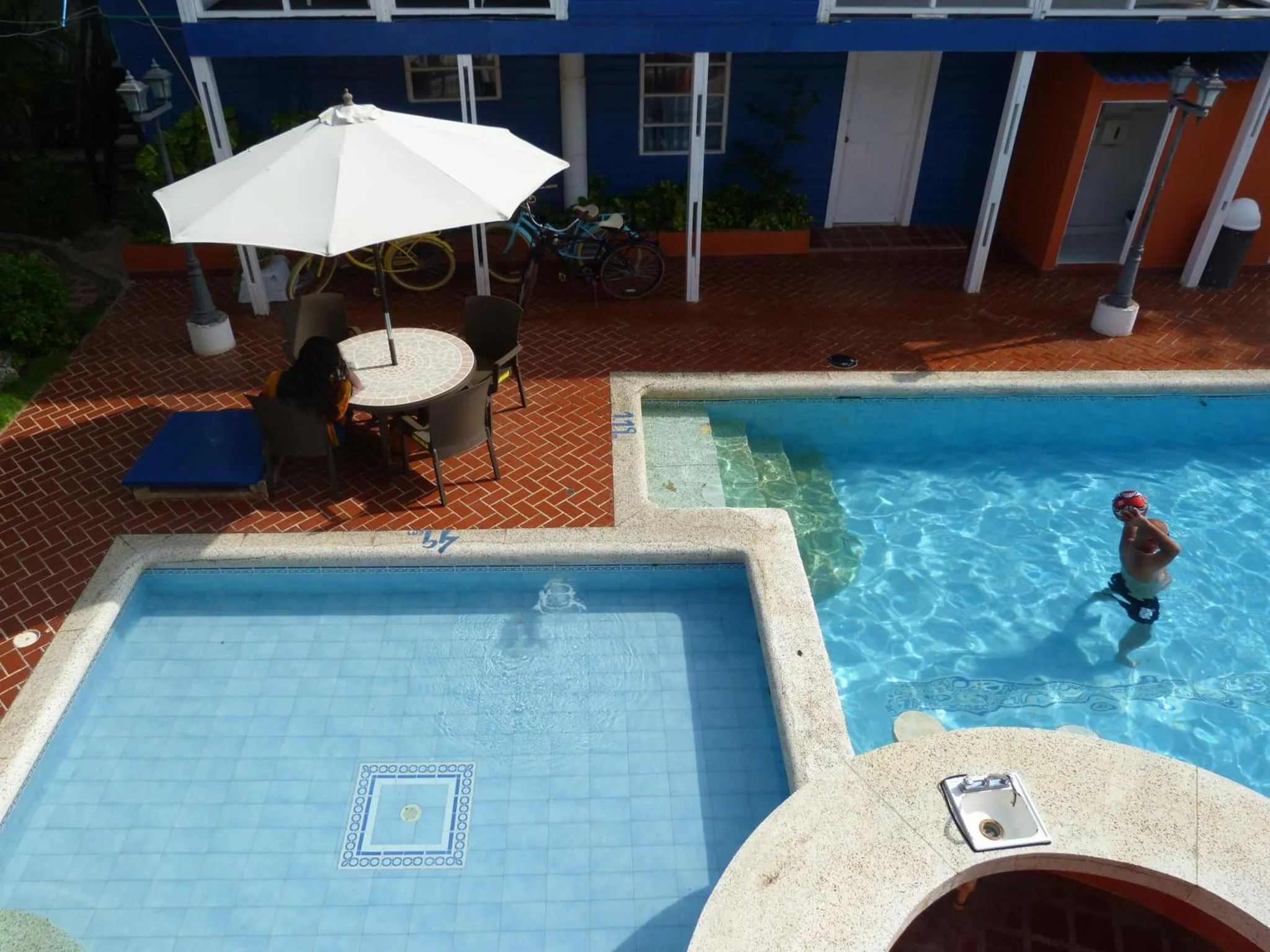 Une piscine avec des transats et une personne sortant de l'eau.