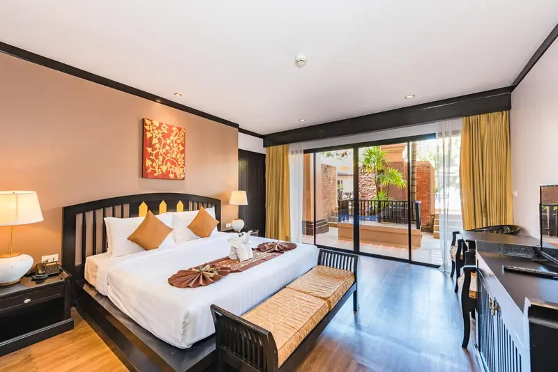 Une chambre avec un grand lit et un accès à une terrasse.