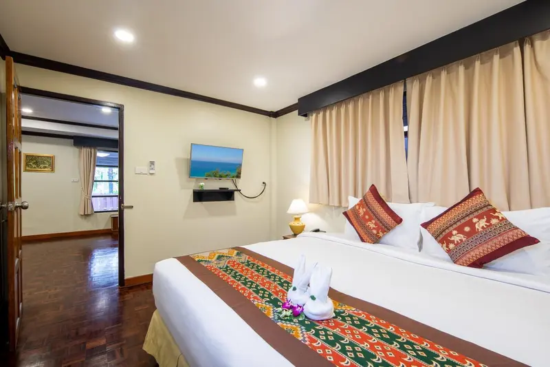 Une chambre lumineuse avec un grand lit et une décoration soignée.