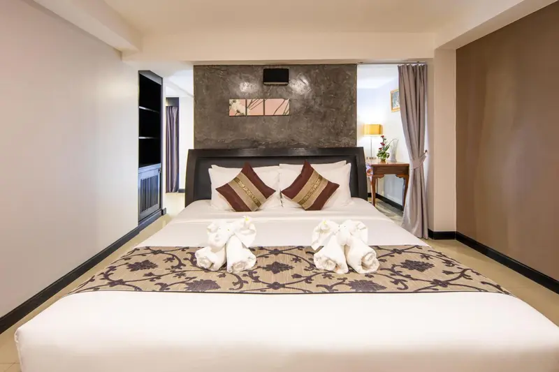 Une chambre avec un grand lit décoré de serviettes en forme de cygnes.