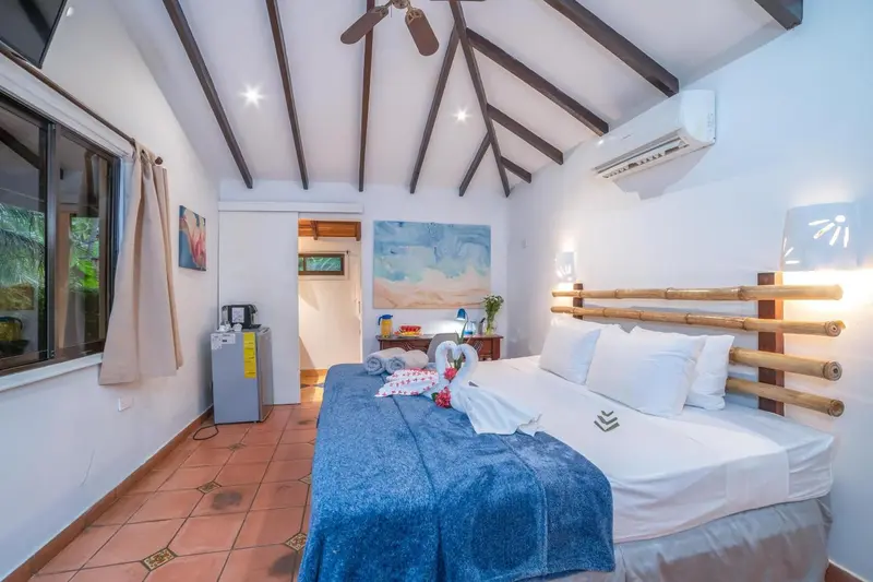 Une chambre lumineuse avec un lit recouvert d'une couverture bleue et décoré de serviettes en forme d'animaux.