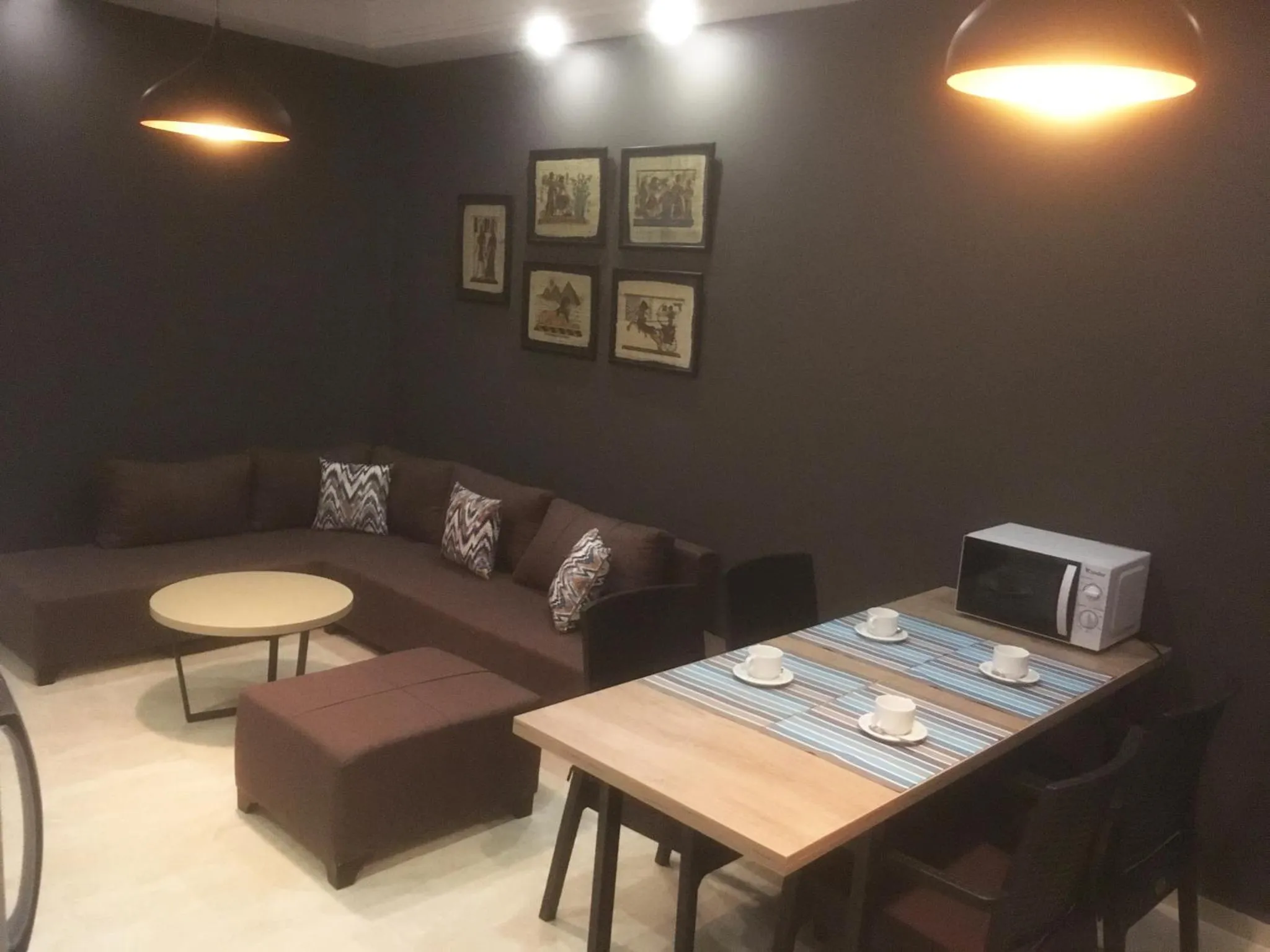 Un espace de détente intérieur avec canapé et table basse, et un coin repas avec table et chaises.