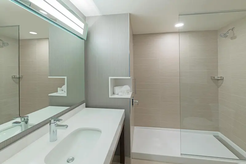 Une salle de bain moderne avec une douche vitrée et un double lavabo.
