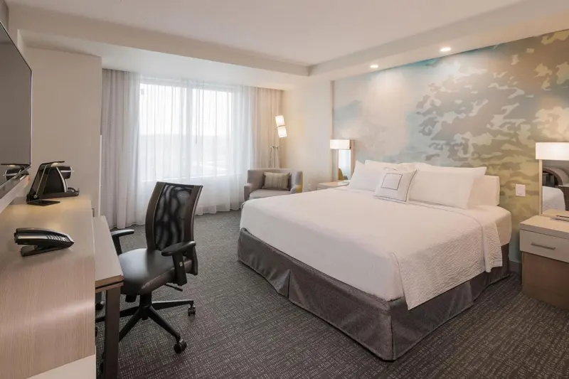 Une chambre d'hôtel lumineuse avec un grand lit et un espace de travail.