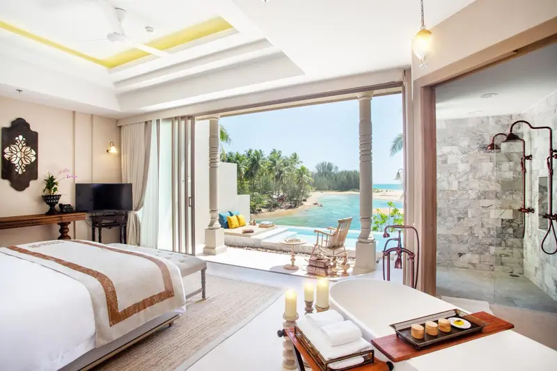 Une chambre lumineuse s'ouvre sur une terrasse avec vue sur la mer.