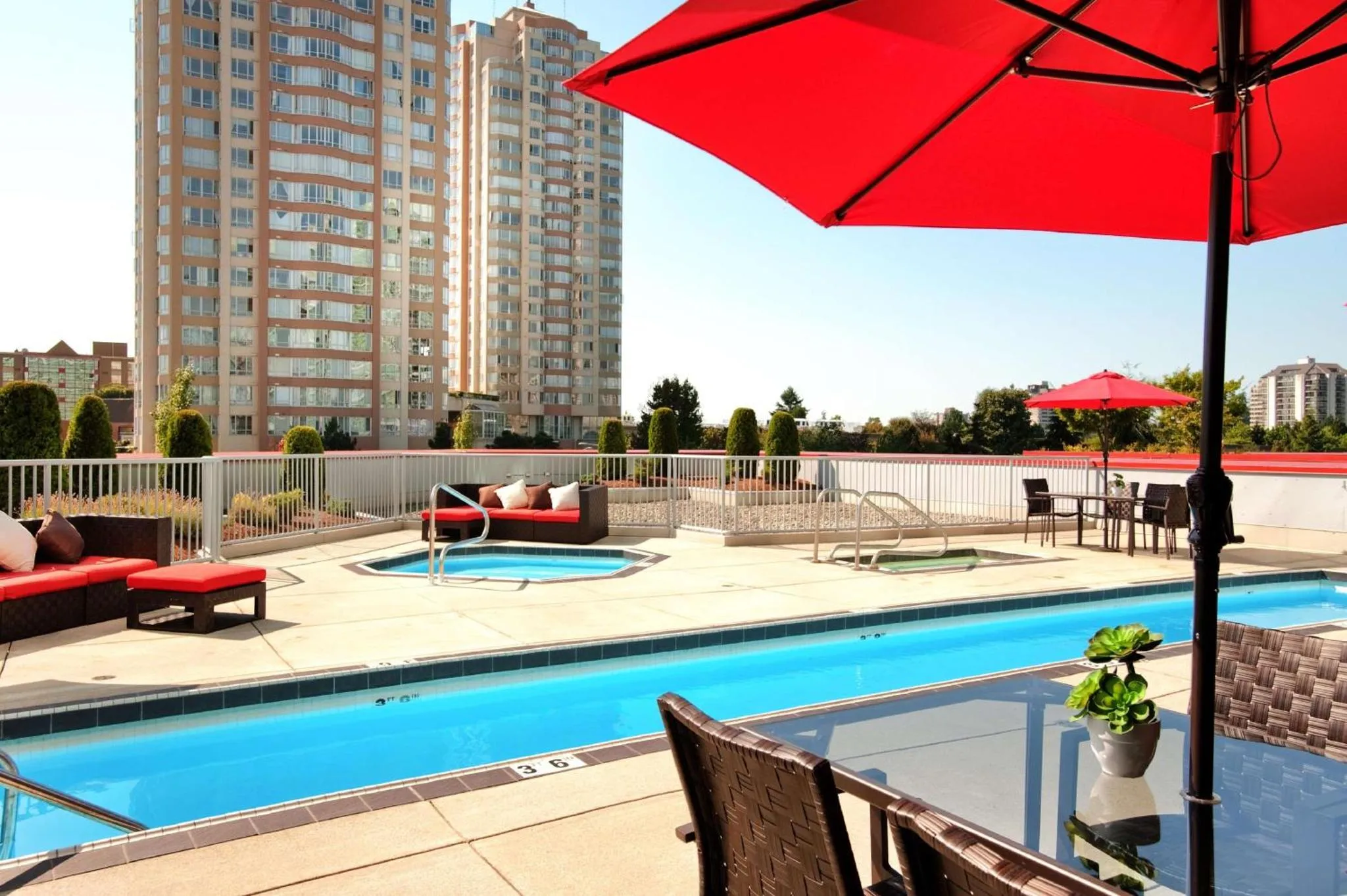 Terrasse avec piscine et mobilier de détente.