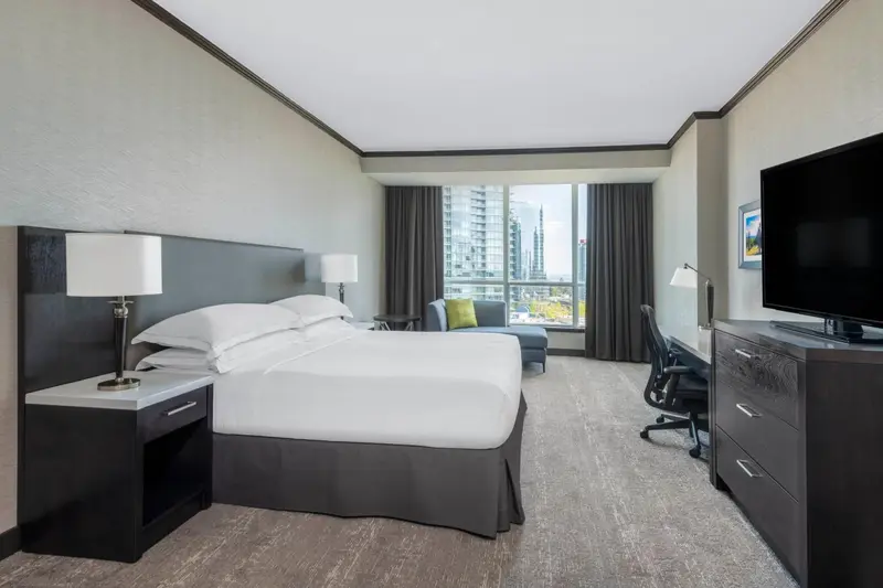 Une chambre d'hôtel moderne avec un grand lit et une vue sur la ville.