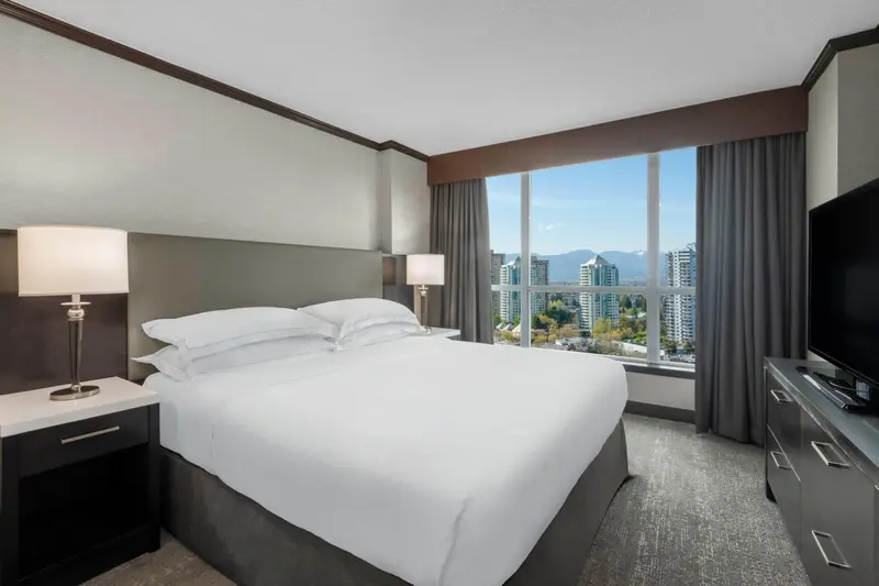 Une chambre d'hôtel avec un grand lit et une vue sur la ville.