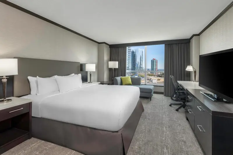 Une chambre d'hôtel moderne avec un grand lit et une vue sur la ville.