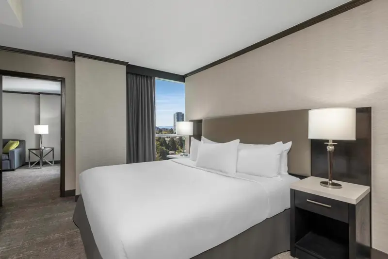 Une chambre d'hôtel moderne avec un grand lit et une vue sur la ville.