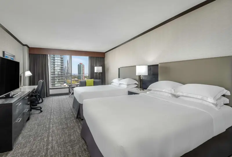 Chambre d'hôtel avec deux lits et vue sur la ville.