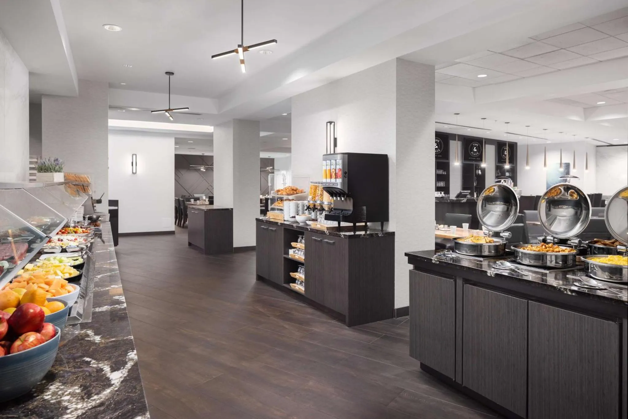Un buffet propose une variété de plats et de boissons dans une salle lumineuse.