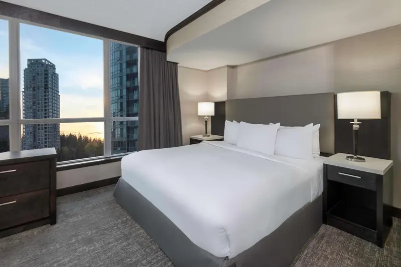 Une chambre d'hôtel moderne avec un grand lit et une vue sur la ville.