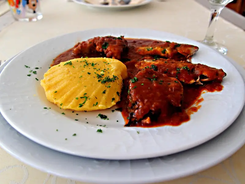 Assiette de poisson sauce tomate accompagnée de polenta.