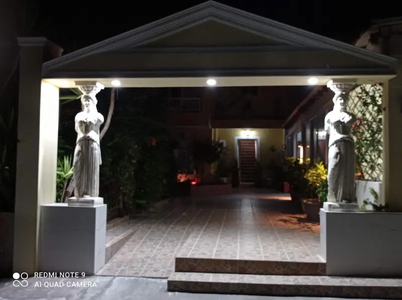 Entree illuminée d'un bâtiment avec des statues de part et d'autre.