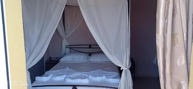 Lit à baldaquin avec décoration florale sur un lit blanc.