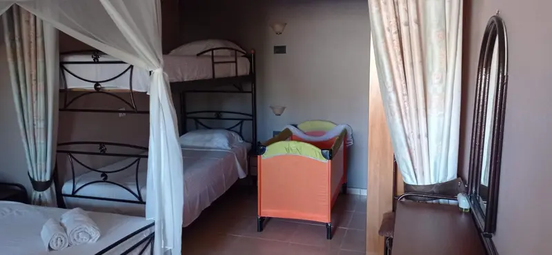 Une chambre avec des lits superposés et des fauteuils colorés.
