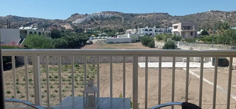 Vue d'un paysage montagneux et d'une végétation luxuriante depuis une terrasse.