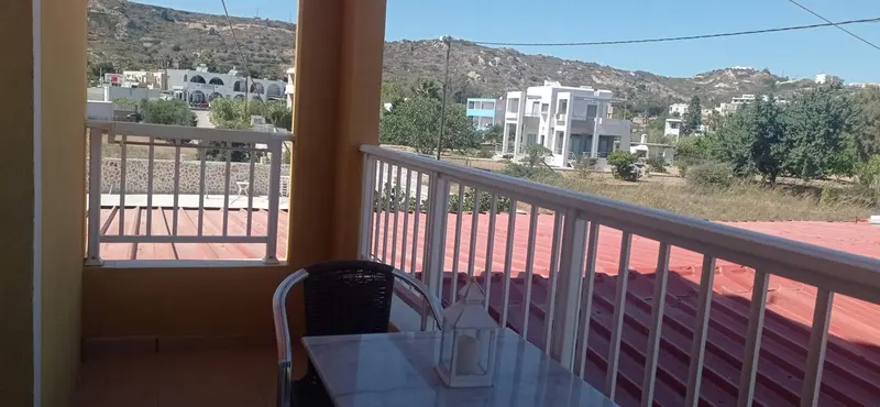 Une terrasse avec une table et des chaises offre une vue sur un paysage montagneux.