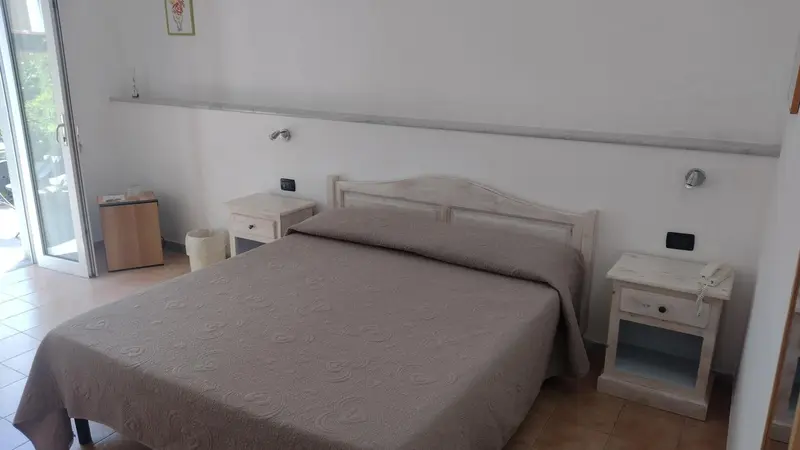 Une chambre lumineuse avec un grand lit et des tables de chevet.