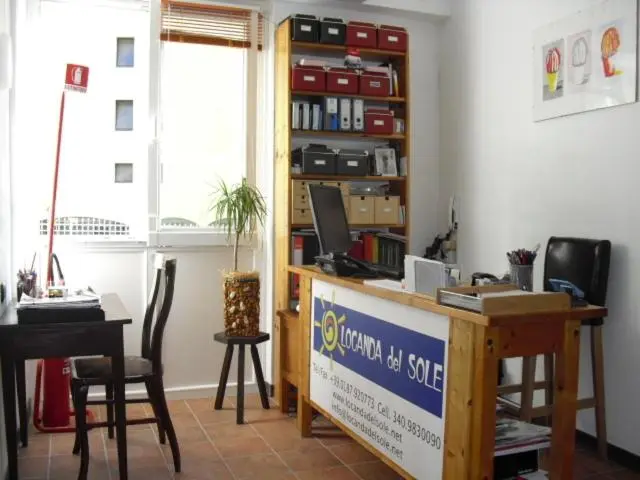 Un bureau d'accueil en bois avec un ordinateur et des dossiers.