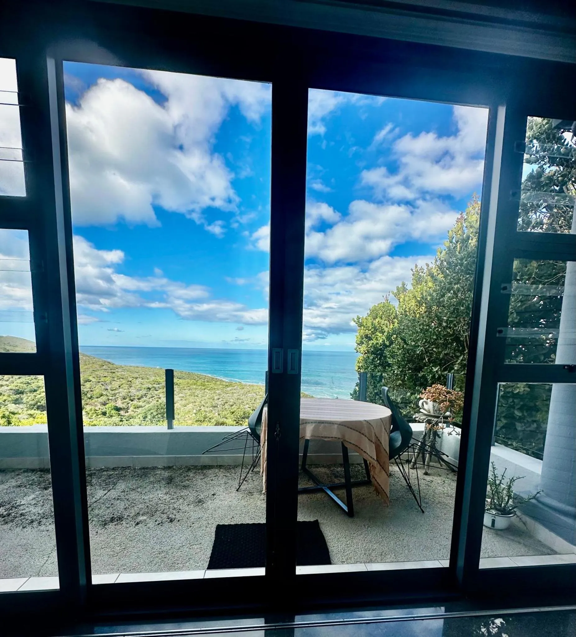Vue sur la mer depuis une terrasse ensoleillée.