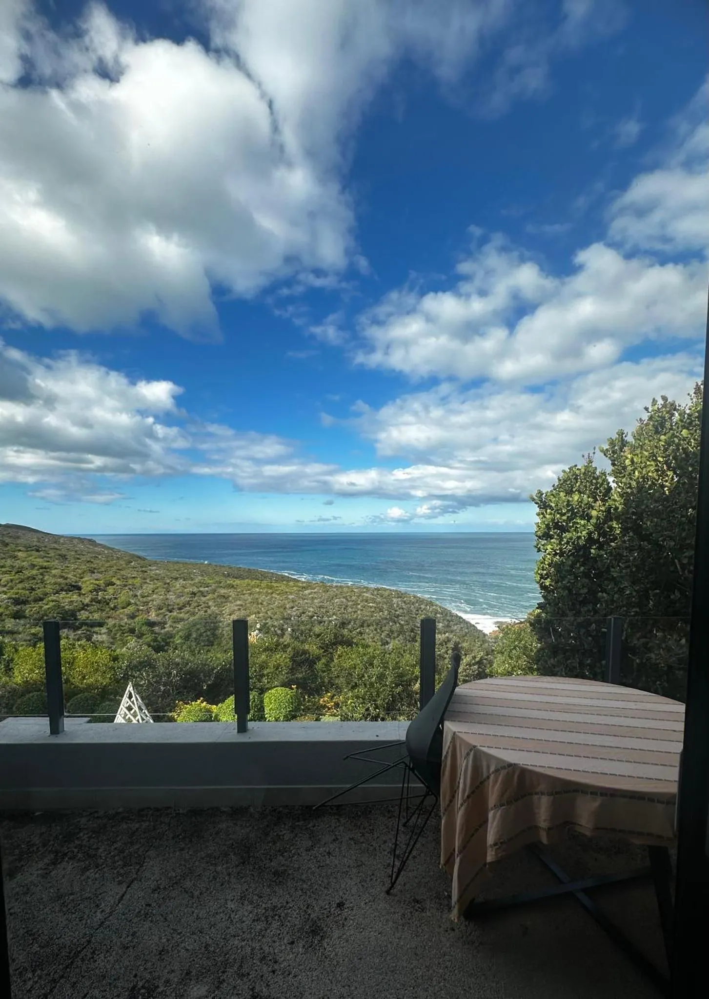 Vue sur la mer depuis une terrasse ombragée.