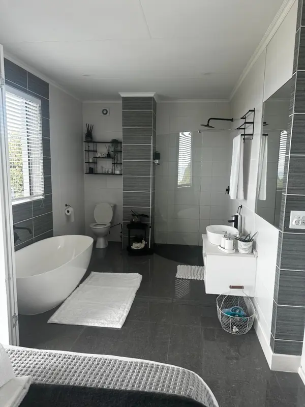 Une salle de bain moderne avec baignoire et douche à l'italienne.